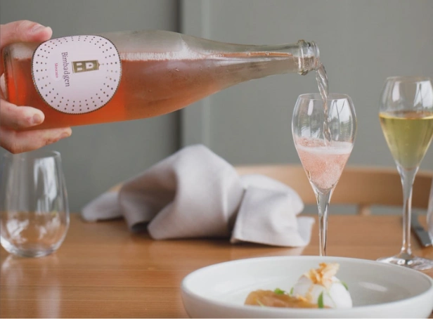 pouring Bimbadgen Sparkling Moscato NV into a glass with panna cotta dessert at Esca Bimbadgen