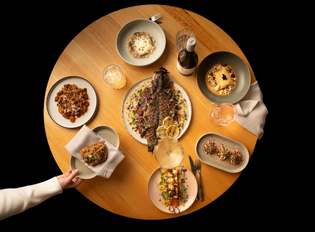 Selection of seasonal dishes and Bimbadgen wines arranged on a table at Esca Bimbadgen in the Hunter Valley.