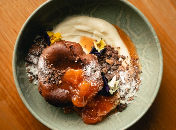 Chocolate dessert with fruit compote, cream and edible flowers at Esca Bimbadgen