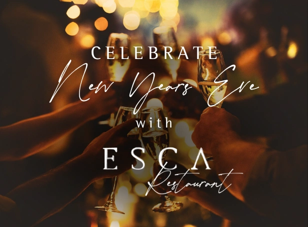 Guests raising sparkling wine glasses during New Year’s Eve dinner at Esca Restaurant